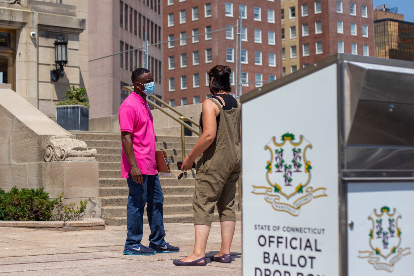 New Haven City Clerk Michael B. Smart talks to a voter outside City Hall, Monday, Aug. 10, 2020.